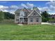 Beautiful two-story brick home with a manicured lawn and lake view at 9411 Stonebridge Way # 49, Mint Hill, NC 28227