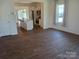 Living room with dark brown vinyl plank flooring and kitchen island view at 13969 Clayborn St, Midland, NC 28107
