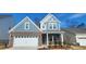 Charming two-story home featuring a brick facade, attached two-car garage, and a welcoming covered entryway at 143 Ella Claire Dr, York, SC 29745