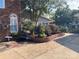Well-manicured backyard featuring a brick facade, mature shrubs, and hardscape at 24756 Strand Dr, Albemarle, NC 28001