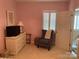 Inviting bedroom featuring a dresser with a TV, a decorative chair, and natural light from the window at 24756 Strand Dr, Albemarle, NC 28001