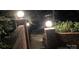 Brick retaining wall with light posts, and a glimpse of backyard landscaping at 24756 Strand Dr, Albemarle, NC 28001