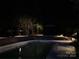 Inviting in-ground pool area with night lighting, landscaping, and clear water at 24756 Strand Dr, Albemarle, NC 28001