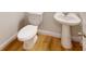 Well-lit half bathroom featuring a toilet, pedestal sink, and wood-style flooring at 515 Tates Trl # 39, Cramerton, NC 28032