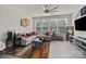 Spacious living room featuring a sectional sofa, large windows, and a ceiling fan at 912 Broad River Ln, Charlotte, NC 28211