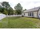 Large backyard with a patio, seating, swing, manicured lawn, and a white picket fence providing privacy at 1041 Kensrowe Ln, Matthews, NC 28104