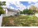 This spacious backyard features a patio set, swing, and trampoline; all enclosed by a white picket fence at 1041 Kensrowe Ln, Matthews, NC 28104