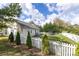 View of the backyard, showcasing a white picket fence, well-maintained lawn, patio set, and mature trees at 1041 Kensrowe Ln, Matthews, NC 28104