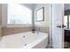 Bright bathroom featuring a garden tub, tile surround, and a window bringing in natural light at 1041 Kensrowe Ln, Matthews, NC 28104