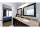 Bathroom featuring a dual-sink vanity with granite countertops, framed mirrors, and access to the bedroom at 1041 Kensrowe Ln, Matthews, NC 28104