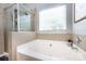 Bright bathroom featuring a garden tub, tile surround, and a window at 1041 Kensrowe Ln, Matthews, NC 28104