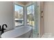 Relaxing bathroom with soaking tub and corner windows overlooking nature at 569 Evergreen Rd, Clover, SC 29710