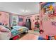 Pink bedroom with rainbow unicorn poster, tv, window and colorful decor at 7686 Hickory Creek Dr, Denver, NC 28037