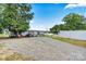 Exterior view of home with a spacious gravel driveway and well maintained yard at 7686 Hickory Creek Dr, Denver, NC 28037