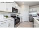 Well-equipped kitchen with white cabinets, quartz countertops, and stainless steel appliances at 107 Rustling Waters Dr, Mooresville, NC 28117
