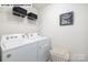 Bright laundry room includes a washer, dryer, shelving, decor, and a stylish laundry basket at 107 Rustling Waters Dr, Mooresville, NC 28117