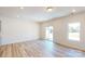 Open-concept living room featuring light wood floors, a sliding glass door, and ample natural light at 4057 Lawnview Dr, Charlotte, NC 28269