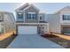 Charming two-story home with a two-car garage, stone accents, and blue siding at 1209 Red River Dr, Salisbury, NC 28144