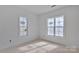 Sunny bedroom featuring unfinished flooring and two large windows at 2059 Parks Rd, Salisbury, NC 28147