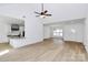 Open-concept living area with sleek wood flooring, ceiling fan, and stylish kitchen view at 2059 Parks Rd, Salisbury, NC 28147