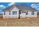 New construction featuring a light gray exterior, gray roof, and brick foundation at 2059 Parks Rd, Salisbury, NC 28147