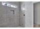 Modern shower design with marble style tiling, a built-in niche, and a small window at 2059 Parks Rd, Salisbury, NC 28147