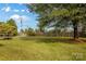 Spacious yard with mature trees and a wooden fence, offering privacy and shade at 5960/5930 S Main St, Salisbury, NC 28147