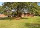 Spacious backyard with a brick home, mature trees, and a lush lawn at 5960/5930 S Main St, Salisbury, NC 28147
