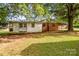 Quaint single-story home with an unfinished exterior and an overgrown lawn, surrounded by mature trees at 5960/5930 S Main St, Salisbury, NC 28147