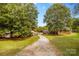Scenic view of the property with a long gravel driveway and multiple buildings surrounded by lush trees at 5960/5930 S Main St, Salisbury, NC 28147