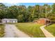 Exterior view of a brick home and detached garage with a spacious yard and gravel driveway at 5960/5930 S Main St, Salisbury, NC 28147