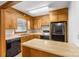 Functional kitchen featuring wooden cabinets, black appliances, and a breakfast bar at 5960/5930 S Main St, Salisbury, NC 28147