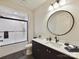 Modern bathroom featuring a black-framed glass shower, dark cabinets, and a stylish round mirror at 8115 Farm Crossing Ln # 3, Huntersville, NC 28078