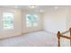 Bright bedroom featuring plush carpeting and multiple windows offering scenic views of the neighborhood at 649 Kitfox Nw Dr, Concord, NC 28027
