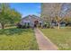 Charming stone ranch house with a well-manicured lawn and walkway at 713 Perkins St, Lowell, NC 28098