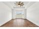 Inviting bedroom featuring a tray ceiling, ceiling fan and large windows at 2025 Parks Rd, Salisbury, NC 28147