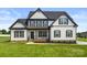 Charming two-story home with a modern white exterior, black shutters, a well-manicured lawn, and covered front porch at 2025 Parks Rd, Salisbury, NC 28147