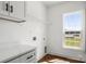 Bright laundry room with white cabinets and natural light from window at 2025 Parks Rd, Salisbury, NC 28147