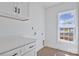Bright laundry room featuring white cabinets with black hardware and a window with natural light at 2025 Parks Rd, Salisbury, NC 28147