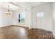 Bright, spacious living room featuring beautiful wood floors, a modern light fixture, large windows, and fresh white paint at 2025 Parks Rd, Salisbury, NC 28147