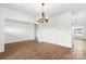 Spacious open-concept living area with wood floors, white walls, a modern chandelier, and abundant natural light at 2025 Parks Rd, Salisbury, NC 28147