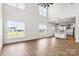 Open-concept living room with soaring ceilings and views of the kitchen, beautiful wood floors, and bright windows at 2025 Parks Rd, Salisbury, NC 28147