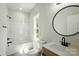 Bathroom featuring a shower-tub combo, modern fixtures, and a round mirror, creating a stylish and functional space at 414 Clinton Ave, Lancaster, SC 29720