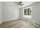 Bright bedroom with wood-look floors and a ceiling fan, bathed in natural sunlight at 414 Clinton Ave, Lancaster, SC 29720