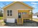 Charming exterior view of a tan home with front porch and wooden staircase at 414 Clinton Ave, Lancaster, SC 29720