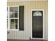 A black front door with a window, surrounded by white trim and black shutters at 414 Clinton Ave, Lancaster, SC 29720