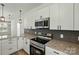 Close-up of an updated kitchen with granite counters, stainless appliances, and sleek black accents at 414 Clinton Ave, Lancaster, SC 29720
