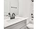 Well-lit bathroom featuring a white vanity with gray cabinets, sink, and bathtub with shower at 602 Meadow Ave, Spencer, NC 28159
