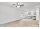 Bright open-concept living space with light wood floors, modern ceiling fan and view into the kitchen at 602 Meadow Ave, Spencer, NC 28159