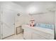 Bright laundry room with washer, dryer, utility sink, shelving and a door to the exterior at 8511 Castledown Dr, Huntersville, NC 28078